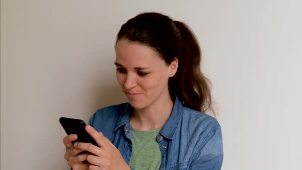 Jonge Blanke Europese Vrouw Shirt Witte Achtergrond Sms Met Smartphone — Stockvideo