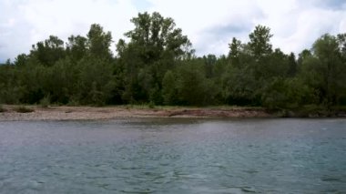 Mavimsi tondan oluşan güzel sakin dağ nehri taşların arasında yavaşça akar yeşil, yoğun yaz ormanlarının arka planına doğru. Dağ nehri dikkat çeker ve dikkat çeker. Yatay 4k gerçek zamanlı video.