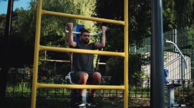 Forma gir ve sağlıklı bir yaşam sür. Ağırlığını iki elinle özel eğitim makinesine ver. Spor caddesi simülatöründe sakallı ve rastalı genç bir sporcunun güçlü eğitimi..