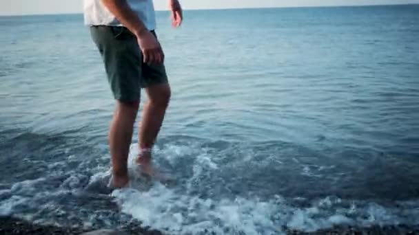 Kaukasischer Mann Kurzen Hosen Geht Langsam Flachen Wasser Des Kiesstrandes — Stockvideo