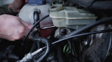 Adam ellerini ve anahtarını kullanarak arabanın vidalarını söker. Fren silindirinin değiştirilmesi ve makinenin restorasyonu. Otomobil tamircisi garajda çalışıyor ve eski arabayı tamir ediyor..