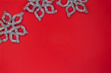 Fotokopi alanı ile kırmızı zemin üzerinde gümüş kar tanelerinden yapılmış çerçeve.