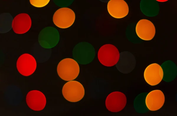 Luzes bokeh circulares multicoloridas no fundo preto escuro. Natal feriado luzes — Fotografia de Stock