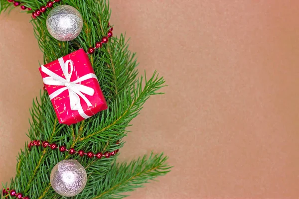 Marco fronterizo de abeto noble verde tradicional con bolas de Navidad, cajas de regalo y guirnaldas sobre fondo de papel artesanal con espacio para copiar. Aplanado. — Foto de Stock