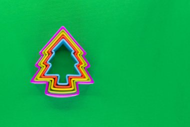 Yeşil arka planda bir Noel ağacı şeklinde çerezler için çok renkli formlar. Noel pişirme seti.