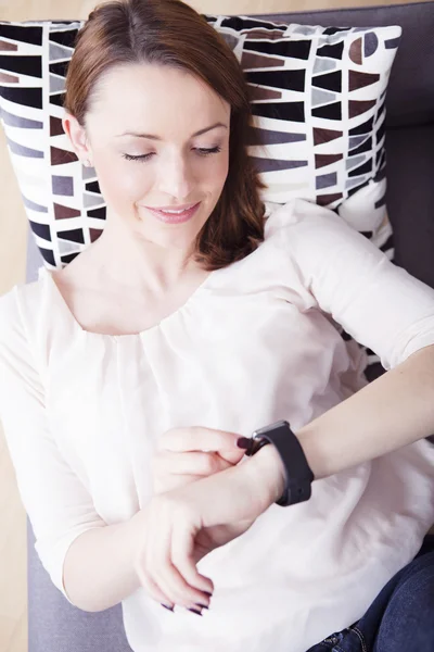 Young beautiful woman with her smartwatch — Stock Photo, Image