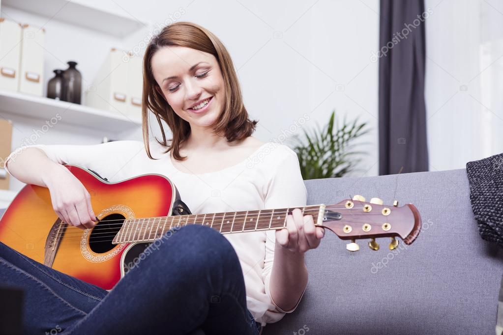 young beautiful woman loves music and is playing guitar