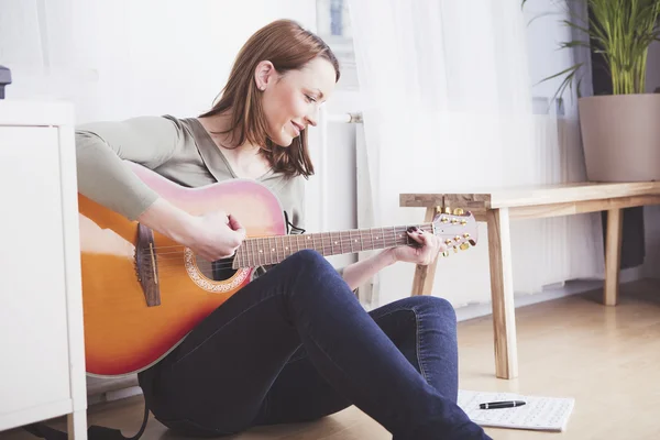 Jovem mulher bonita adora música e está tocando guitarra — Fotografia de Stock