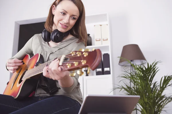 Young beautiful woman loves music and is playing guitar — Stock Photo, Image