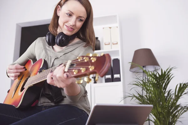 Genç güzel kadın müzik seviyor ve gitar çalmak — Stok fotoğraf