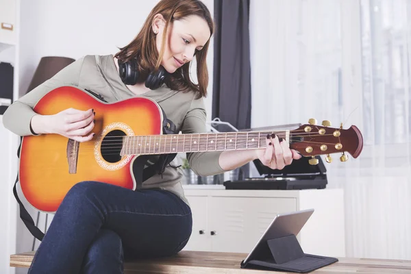 Jovem mulher bonita adora música e está tocando guitarra — Fotografia de Stock