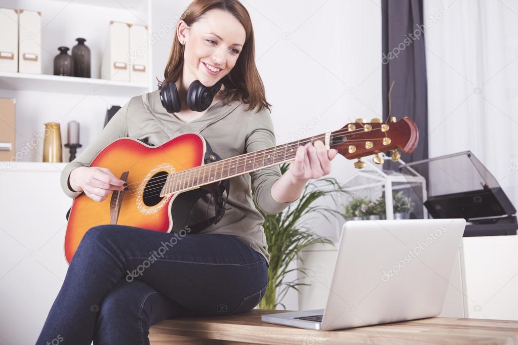 young beautiful woman loves music and is playing guitar