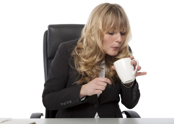Geschäftsfrau bläst auf einen Becher heißen Kaffee — Stockfoto