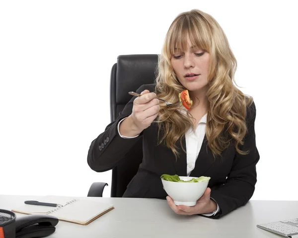 Podnikatelka jíst salát u svého psacího stolu — Stock fotografie