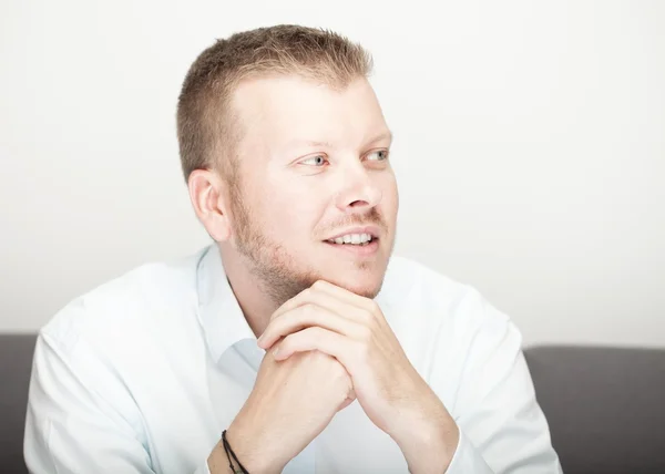 Young man watching and smiling to himself — Stock Photo, Image