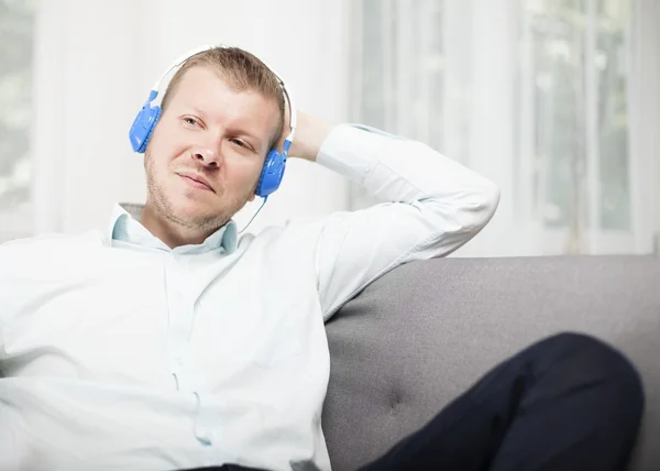 Man smiling to himself as he listens to music — Stock Photo, Image