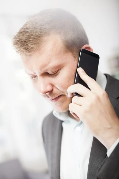 Бизнесмен, хмурящийся при звонке на мобильный — стоковое фото