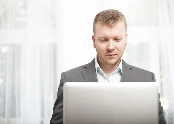 Hombre de negocios serio que trabaja en su computadora portátil —  Fotos de Stock