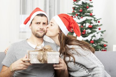man is sceptical about christmas gift clipart