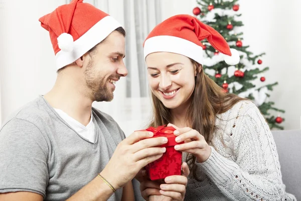 Young couple opens christmas gift box — Stock Photo, Image