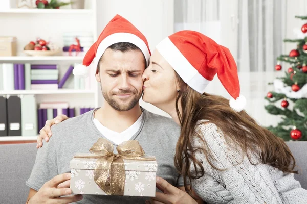 Boyfriend looks skeptical to his christmas gift — Stock Photo, Image