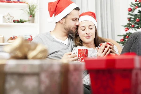 Giovane coppia di Natale rilassante sul divano — Foto Stock
