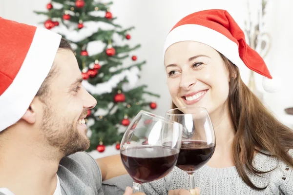 Paar genieten van chistmas met wijn op Bank — Stockfoto