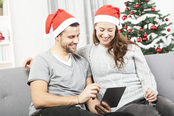 Feliz pareja mira en la tableta PC para Navidad — Foto de Stock