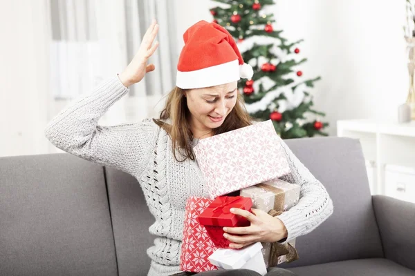 Young girl is confused with christmas gifts — Stock Photo, Image