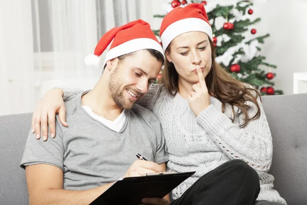 Pareja piensa en hacer una lista para Navidad — Foto de Stock