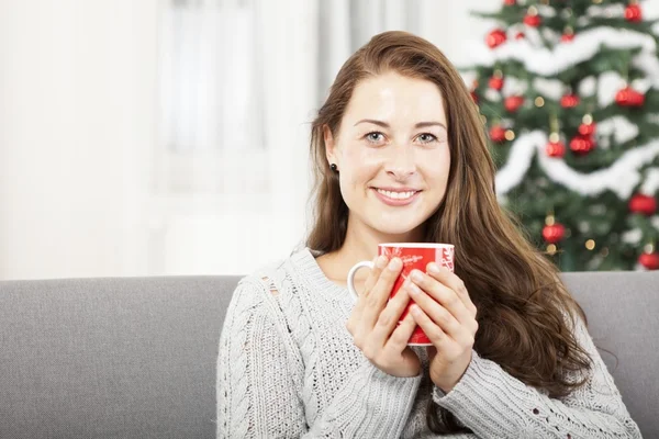 Chica joven que se relaja con té caliente en Navidad —  Fotos de Stock