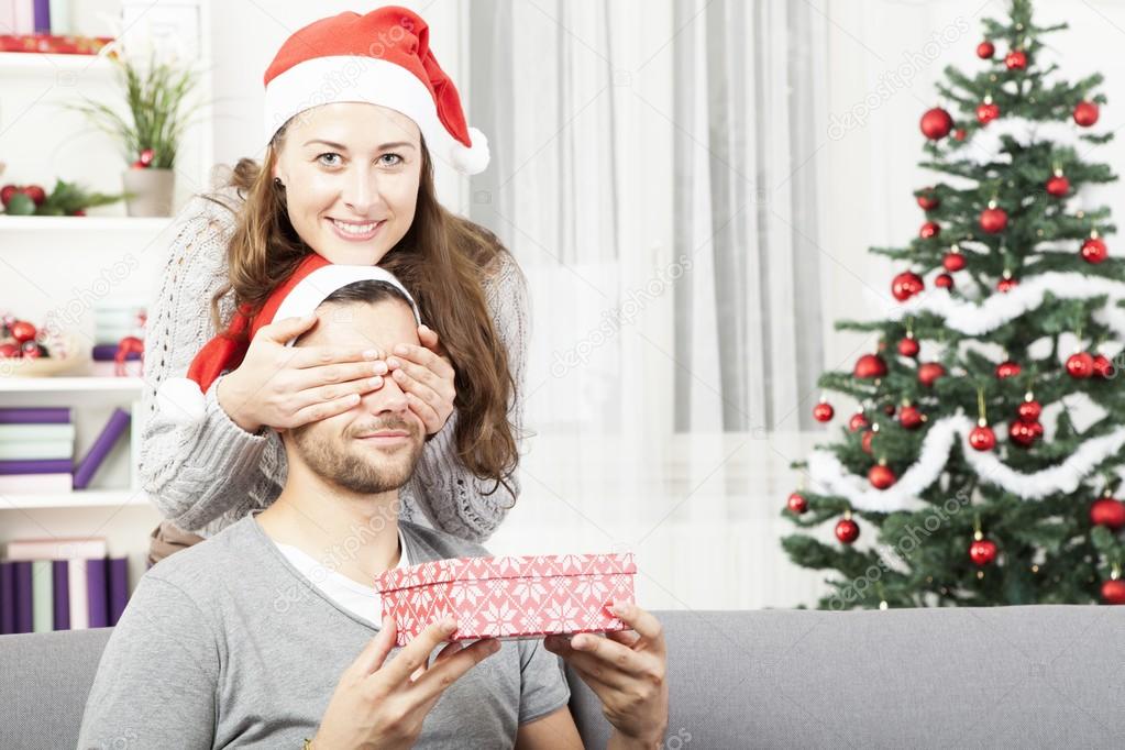 Girls makes her boyfriend a christmas gift — Stock Photo