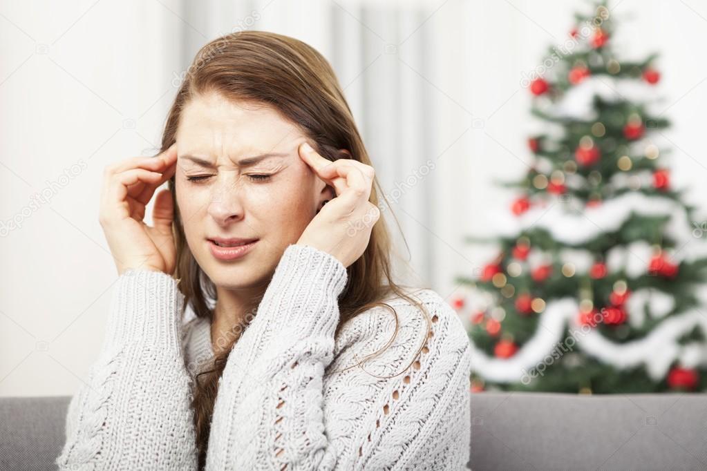 Young girl has headache of christmas stress Stock Photo by