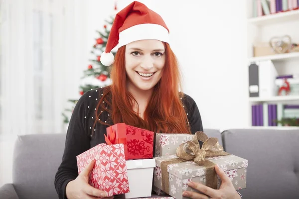 Flickan är nöjd med en hel del julklapp — Stockfoto