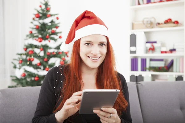 Mädchen liest etwas für Weihnachten auf dem Tablet — Stockfoto