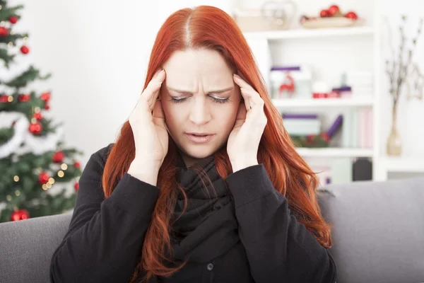 Mujer tiene dolor de cabeza en Navidad — Foto de Stock