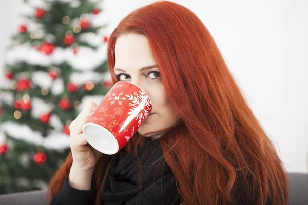 Kvinne drikker kaffe eller te på julaften – stockfoto