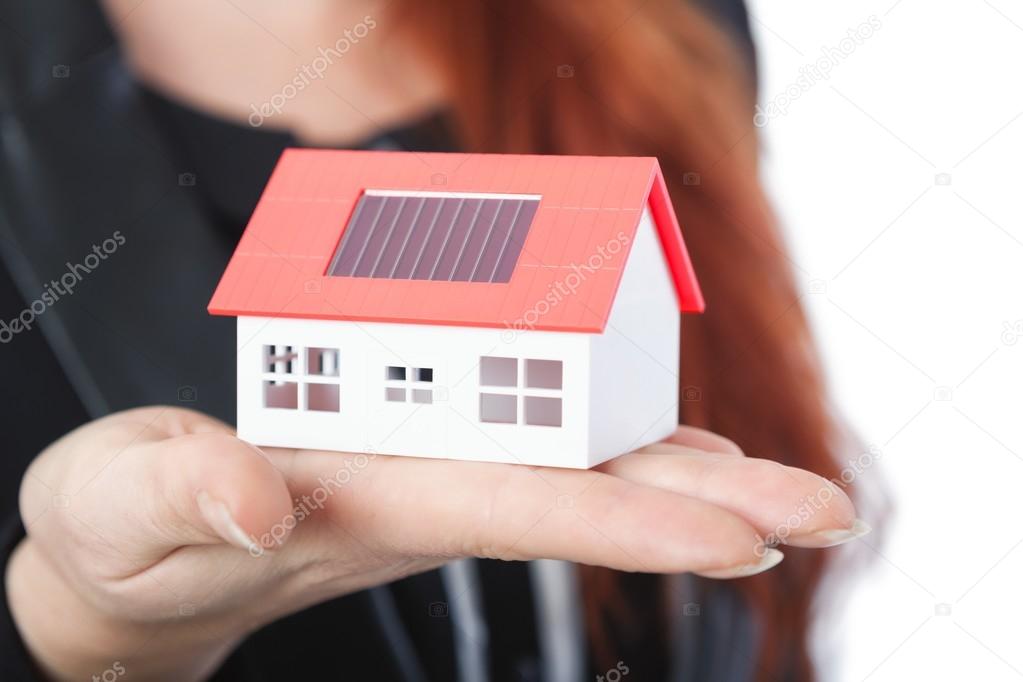 business woman with close up of mini solar house