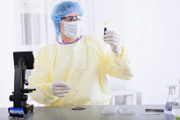 Doctor in protective gear holding blood sample — Stock Photo, Image