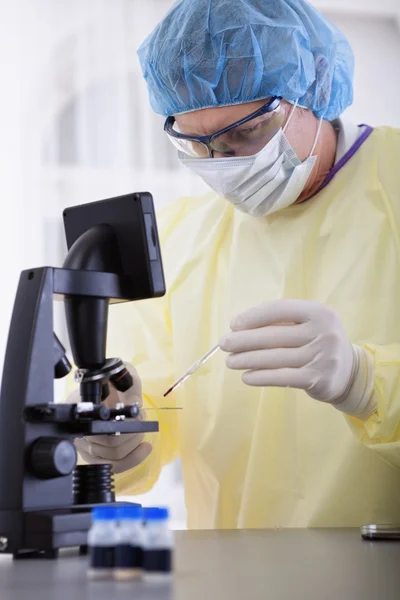 Doctor en equipo protector sosteniendo la muestra de sangre —  Fotos de Stock