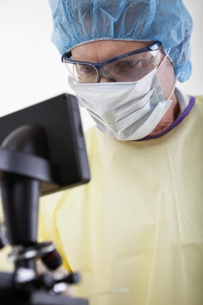 Doctor en equipo protector sosteniendo la muestra de sangre — Foto de Stock