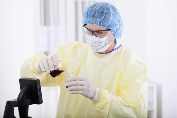 Лікар в захисному спорядженні, що тримає зразок крові — стокове фото