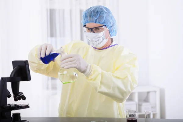 Doctor in protective gear holding blood sample — Stock Photo, Image