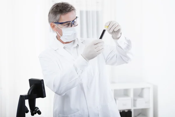 Doctor working with microscope and blood — Stock Photo, Image