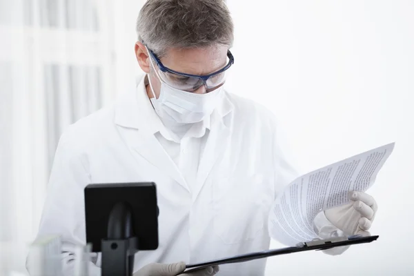 Doctor working with clipboard and blood — Stock Photo, Image