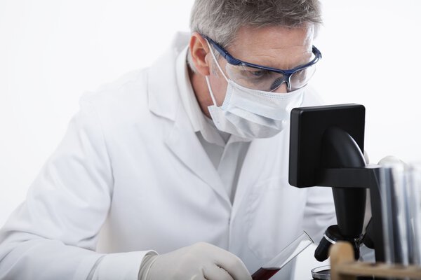 doctor looking on microscope and analyse blood