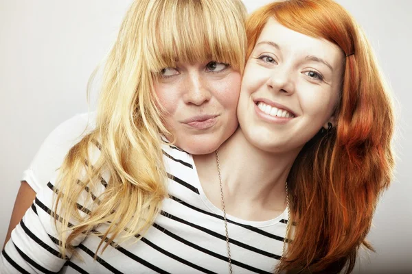 red and blond haired girls friend laughing and hug