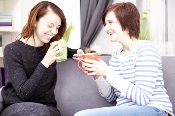 Zwei glückliche Freundinnen mit Kaffeetassen — Stockfoto