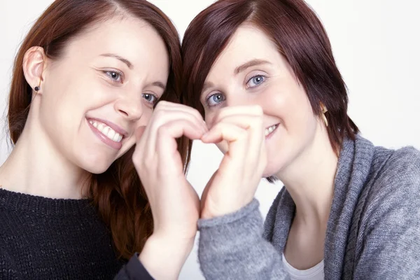 Two girls friends make a heart with hands — Stock Photo, Image