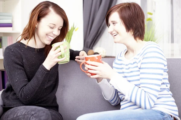 Дві щасливі друзі-жінки з чашками кави Стокова Картинка